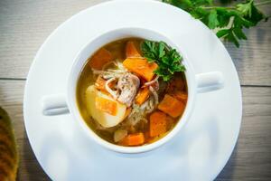 Autumn soup with chicken, noodles and autumn vegetables in a bowl . photo