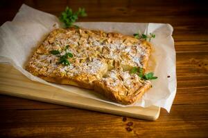 prepared curd semolina pie with quince inside and covered with powdered sugar . photo