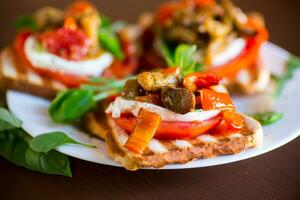 Prepared sandwich with tomatoes, mozzarella and fried eggplant with mushrooms. photo