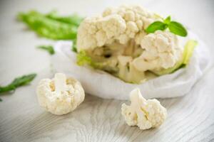 inflorescences of small cauliflower on a light wooden table photo