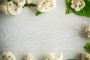 inflorescences of small cauliflower on a light wooden table photo