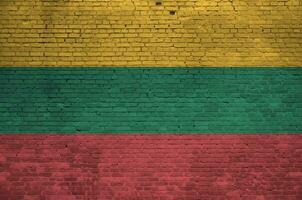 Lithuania flag depicted in paint colors on old brick wall. Textured banner on big brick wall masonry background photo