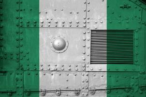 Nigeria bandera representado en lado parte de militar blindado tanque de cerca. Ejército efectivo conceptual antecedentes foto