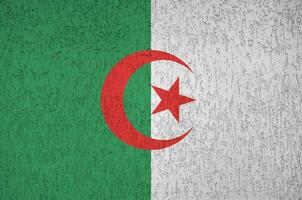 Algeria flag depicted in bright paint colors on old relief plastering wall. Textured banner on rough background photo