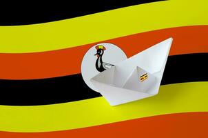 Uganda flag depicted on paper origami ship closeup. Handmade arts concept photo