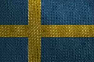 Sweden flag depicted in paint colors on old brushed metal plate or wall closeup. Textured banner on rough background photo