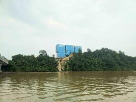 view of the building on the river bank and surrounded by trees photo