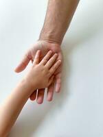 adulto y niño sostener su manos juntos. padres día niño da mano a adulto foto