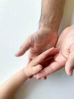 Adult and child hold their hands together. Fathers Day Child gives hand to adult photo