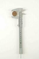 a caliper with a coin on a white background photo