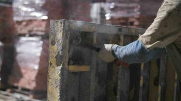 arbetstagare på en konstruktion webbplats bryter betong med en hammare video
