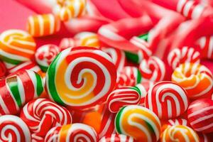 many colorful candy candies on a red background. AI-Generated photo