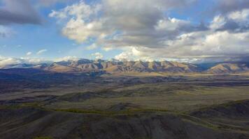 Kurai Steppe and Kurai Mountain Ridge at Sunset. Yellow Larches in Autumn. Altai Mountains, Russia. Drone Hyper Lapse, Time Lapse video