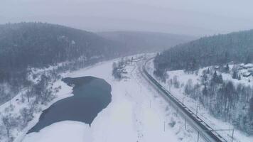 cargaison train et congelé rivière. hiver paysage. aérien voir. video