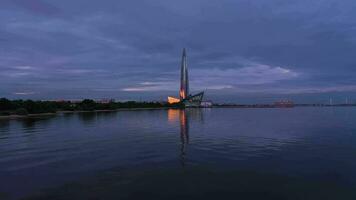 San Petersburgo, Rusia - junio 21, 2019 lakhta centrar torre a noche crepúsculo. reflexión en agua. aéreo vista. Rusia. zumbido moscas oblicuo a bajo nivel video