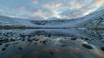 Akademicheskoye Lake in Khibiny Mountains at Sunset in Winter and Reflection. Russia. Time Lapse video