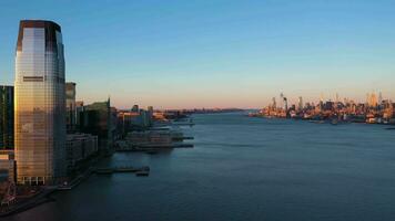 Jersey stad, Verenigde Staten van Amerika - januari 23, 2021 stedelijk Manhattan en Jersey stad horizon Bij zonsondergang en Hudson rivier. antenne visie. Verenigde Staten van Amerika. dar vliegt vooruit video