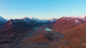 Beltirdu Mountain Ridge. Green Hills, Lakes and River in Autumn at Sunrise. Aerial View. Kosh-Agachsky District, The Altai Mountains, Russia. Drone Flies Backwards video