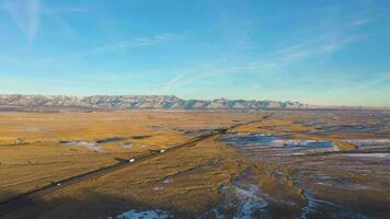 Wüste, Straße mit Autos und Berge beim Sonnenuntergang im Winter. Utah, USA. Antenne Sicht. Drohne fliegt nach vorne video