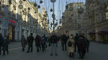 Moscou, Rússia - dezembro 5, 2020 Tempo lapso do homem dentro mascarar em pé ainda em Nikolskaya rua e usando Smartphone durante coronavírus covid-19 pandemia dentro inverno. multidão do pessoas video