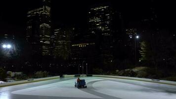 NEW YORK CITY, USA - JANUARY 22, 2021 Ice Resurfacer is Cleaning and Smoothing Ice on Wollman Rink in Central Park in the Evening. Midtown Manhattan Cityscape. video