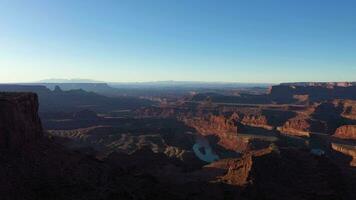 dood paard punt staat park Bij zonsopkomst. Colorado rivier, rood Ravijn en Doorzichtig lucht. Utah, Verenigde Staten van Amerika. antenne visie van meander overzien. dar vliegt achteruit video