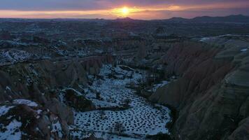 Cappadocia in Winter at Sunset. Snowy Hills and Pillars. Turkey. Aerial View. Drone Flies Forward, Tilt Up. Reveal Shot video