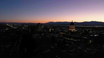 illuminé sel Lac ville à le coucher du soleil à nuit dans l'hiver. Capitole colline. Utah, Etats-Unis. aérien voir. bleu heure. drone mouches vers le haut video