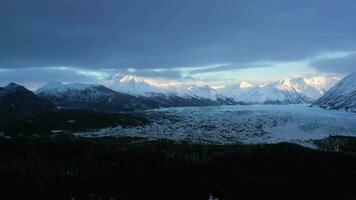 matanuska geleira terminal, coberto de neve montanhas e floresta em nublado dia. Alasca, EUA. aéreo visualizar. zangão moscas lateralmente video