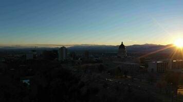 sal lago ciudad, Estados Unidos - enero 30, 2021 sal lago ciudad a puesta de sol en invierno. Utah, EE.UU. aéreo vista. dorado hora. zumbido moscas adelante y hacia arriba video
