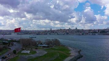 Beyoglu and Fatih Districts of Istanbul on Cloudy Day in Spring. Golden Horn and Galata Bridge. Flag of Turkey. Aerial View. Drone Flies Upwards video