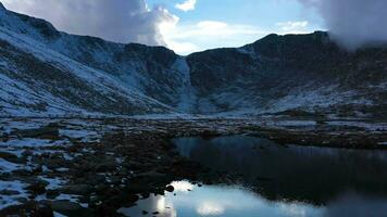 cume lago parque dentro montar Evans área. Nevado montanhas reflexão dentro lago e nublado céu. aéreo visualizar. Colorado, EUA. zangão moscas lateralmente às baixo nível sobre lago video