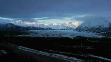 matanuska gletsjer eindpunt, met sneeuw bedekt bergen en Woud Aan bewolkt dag. Alaska, Verenigde Staten van Amerika. antenne visie. dar vliegt vooruit video