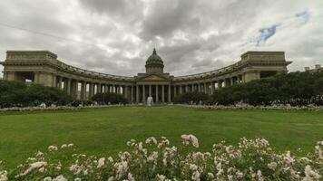 Saint-Pétersbourg, Russie - juin 24, 2019 kazan cathédrale, prairie, fleurs et gens sur nuageux été journée. mouvement panoramique temps laps. video