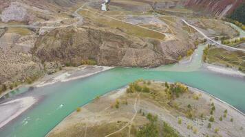 The confluence of Chuya and Katun rivers in Autumn. Aerial View. The Altai Mountains, Russia. Drone flies sideways video