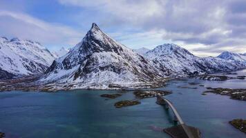 Fredvang puente y volandstind montaña en invierno. flakstadoya, lofoten islas, paisaje de Noruega. aéreo hiper lapso, hora lapso. zumbido moscas adelante y hacia arriba video