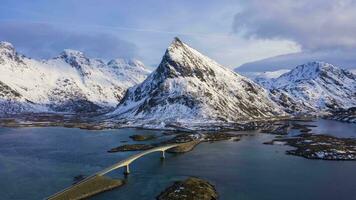 Fredvang bro och volandstind berg i vinter- på solnedgång. flakstadoya, lofoten öar, landskap av Norge. antenn hyper upphöra, tid upphöra. Drönare flugor framåt- och uppåt video