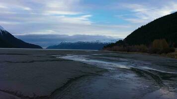 River and Snow-Capped Mountains on Autumn Day. Landscape of Alaska, USA. Aerial View. Drone Flies Forward Slowly over the River at Low Level. Slider Shot video