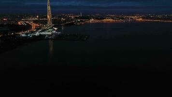 SAINT-PETERSBURG, RUSSIA - JUNE 22, 2019 Illuminated Lakhta Center Skyscraper and Saint-Petersburg Cityscape at Night. Aerial View. Russia. Drone Flies Sideways, Tilt Up video