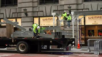 NEW YORK CITY, USA - JANUARY 23, 2021 Construction Workers Scaffolding in Manhattan During Coronavirus Pandemic. People Wearing Masks and Cars Passing By. Medium Shot video