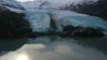 porteo glaciar, porteo lago, reflexión y nevadas montañas en soleado día. Alaska, EE.UU. aéreo vista. zumbido moscas oblicuo, inclinación arriba video