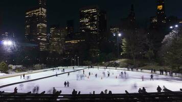personas patinaje sobre hielo en Pista de hielo en central parque en el noche. centro de la ciudad paisaje urbano manhattan nuevo York ciudad, EE.UU. hora lapso video