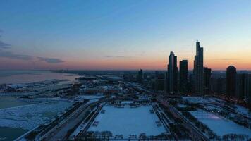 chicago lus, bevroren meer Michigan en wolkenkrabbers van in de buurt zuiden kant wijk Bij zonsondergang. blauw uur. ijzig winter. antenne visie. Verenigde staten van Amerika. dar vliegt vooruit video