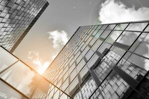 Modern architectural details. Modern glass facade with a geometric pattern. Contemporary corporate business architecture. Red sun on horizon. Black and white toned image. photo