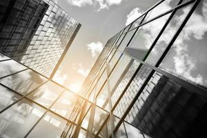 Modern architectural details. Modern glass facade with a geometric pattern. Contemporary corporate business architecture. Red sun on horizon. Black and white toned image. photo