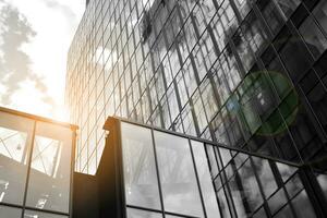 Modern architectural details. Modern glass facade with a geometric pattern. Contemporary corporate business architecture. Red sun on horizon. Black and white toned image. photo