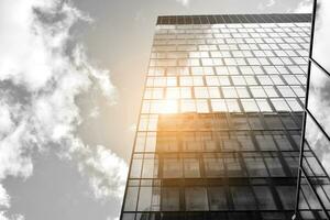 Modern architectural details. Modern glass facade with a geometric pattern. Contemporary corporate business architecture. Red sun on horizon. Black and white toned image. photo