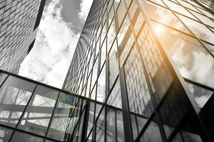 Modern architectural details. Modern glass facade with a geometric pattern. Contemporary corporate business architecture. Red sun on horizon. Black and white toned image. photo