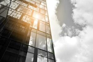 Modern architectural details. Modern glass facade with a geometric pattern. Contemporary corporate business architecture. Red sun on horizon. Black and white toned image. photo