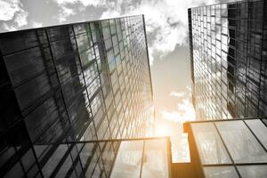Modern architectural details. Modern glass facade with a geometric pattern. Contemporary corporate business architecture. Red sun on horizon. Black and white toned image. photo